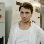 Mężczyzna w białej koszuli w nowoczesnej pralni profesjonalnej