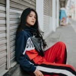Młoda kobieta w streetwearze pozuje na tle miasta w stylu Gucci