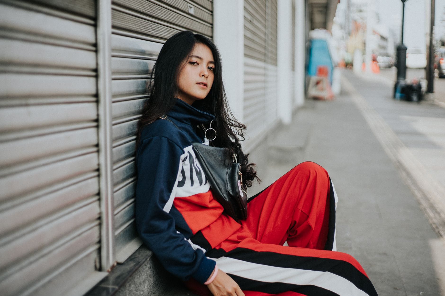 Młoda kobieta w streetwearze pozuje na tle miasta w stylu Gucci