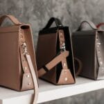 Skórzane torebki na białej półce w minimalistycznym stylu YSL