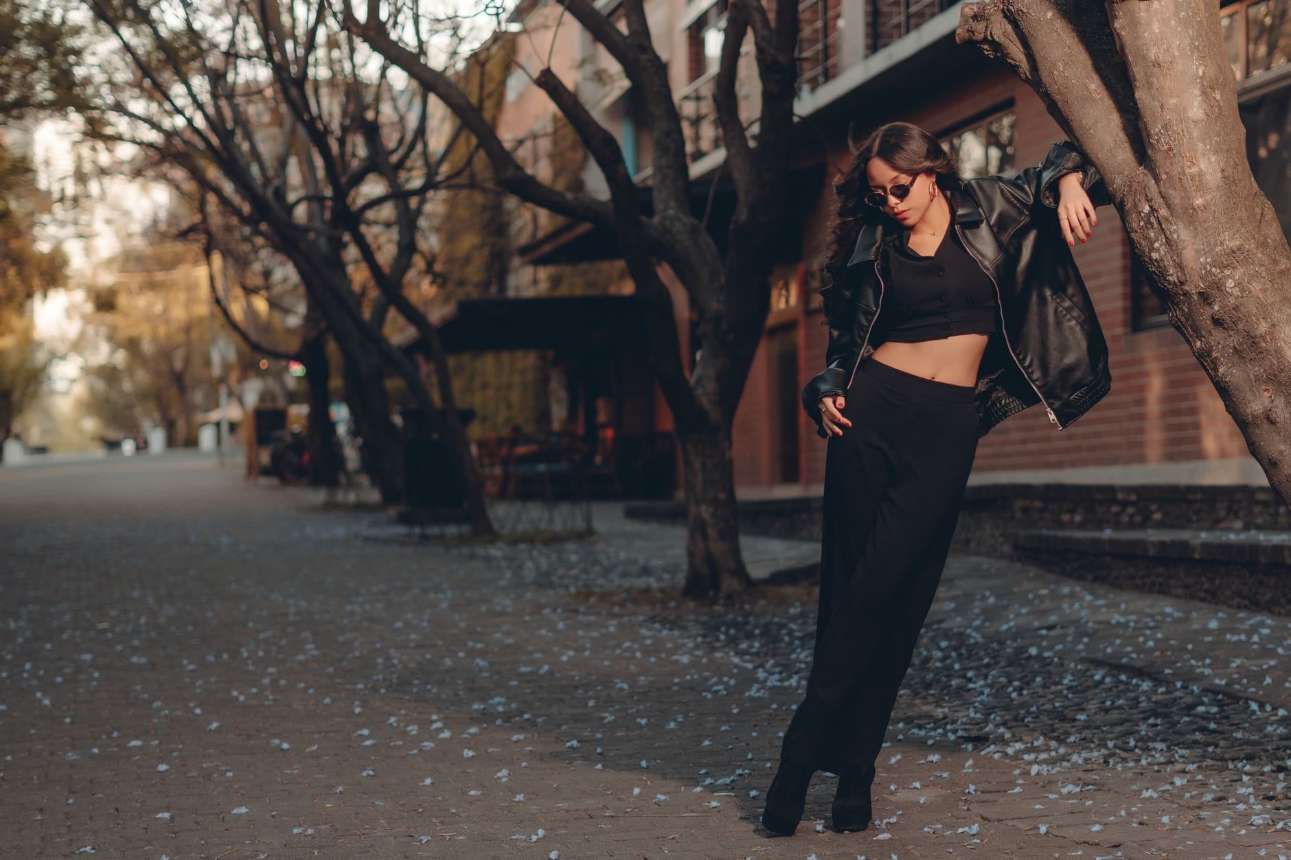 Jak nosić monogram Gucci, żeby wyglądał świeżo, a nie krzykliwie? Stylowa kobieta w czarnej skórzanej kurtce na miejskiej ulicy